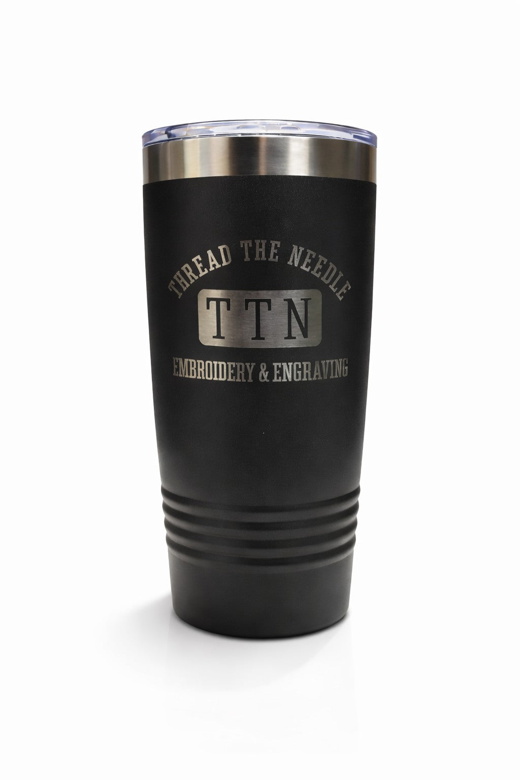 Black tumbler with 'Thread the Needle Embroidery & Engraving' branding on a white background